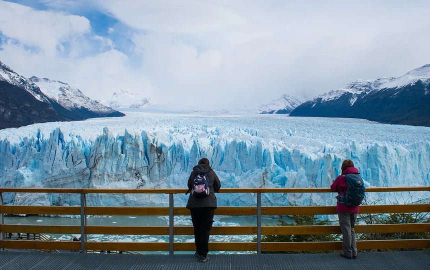 two people admiring a glacier